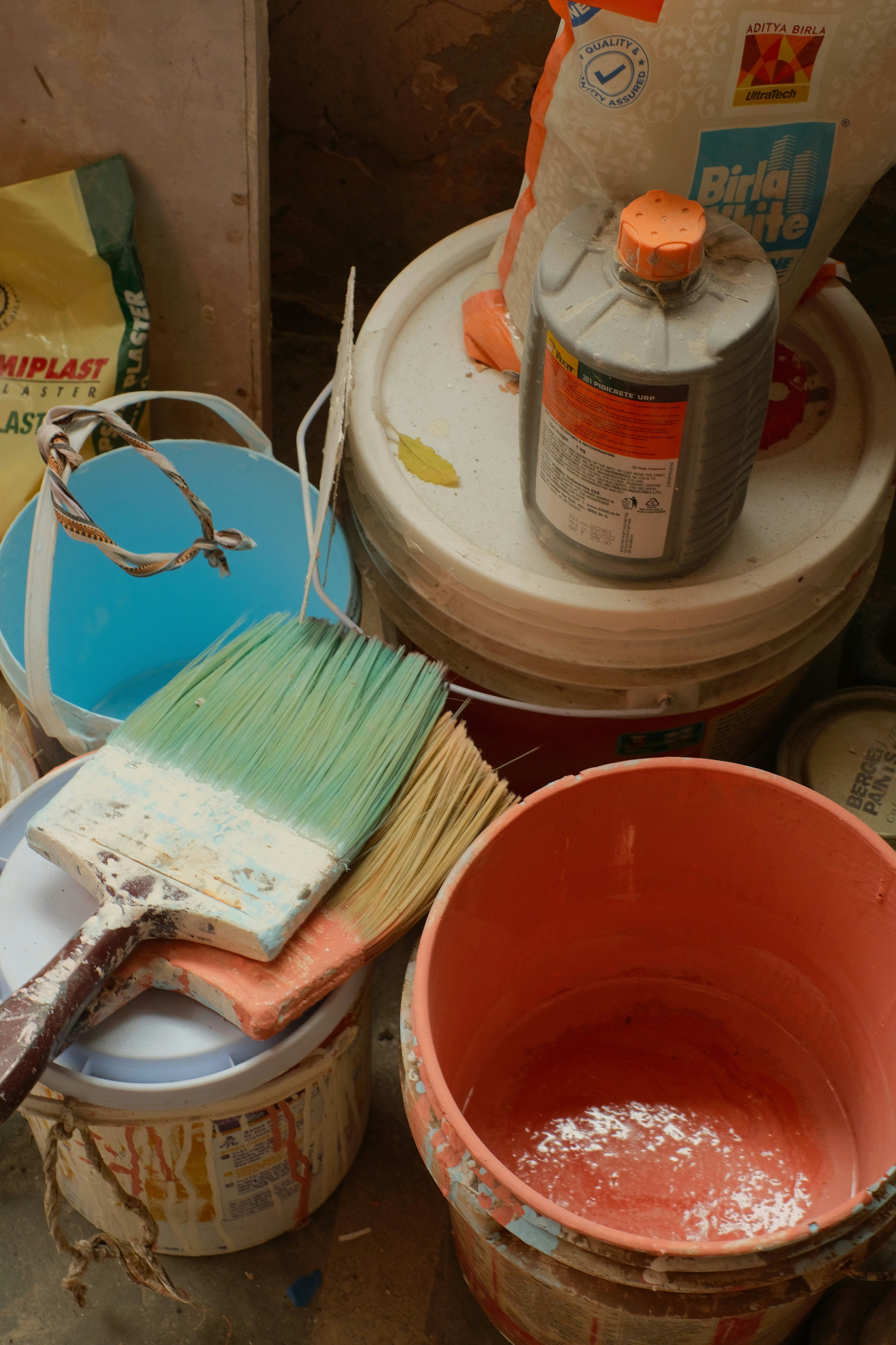 image of paintbrush painting white wall with gray paint